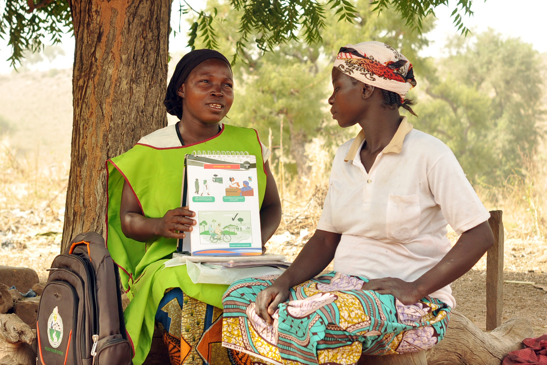 A village health worker shares information with a woman.