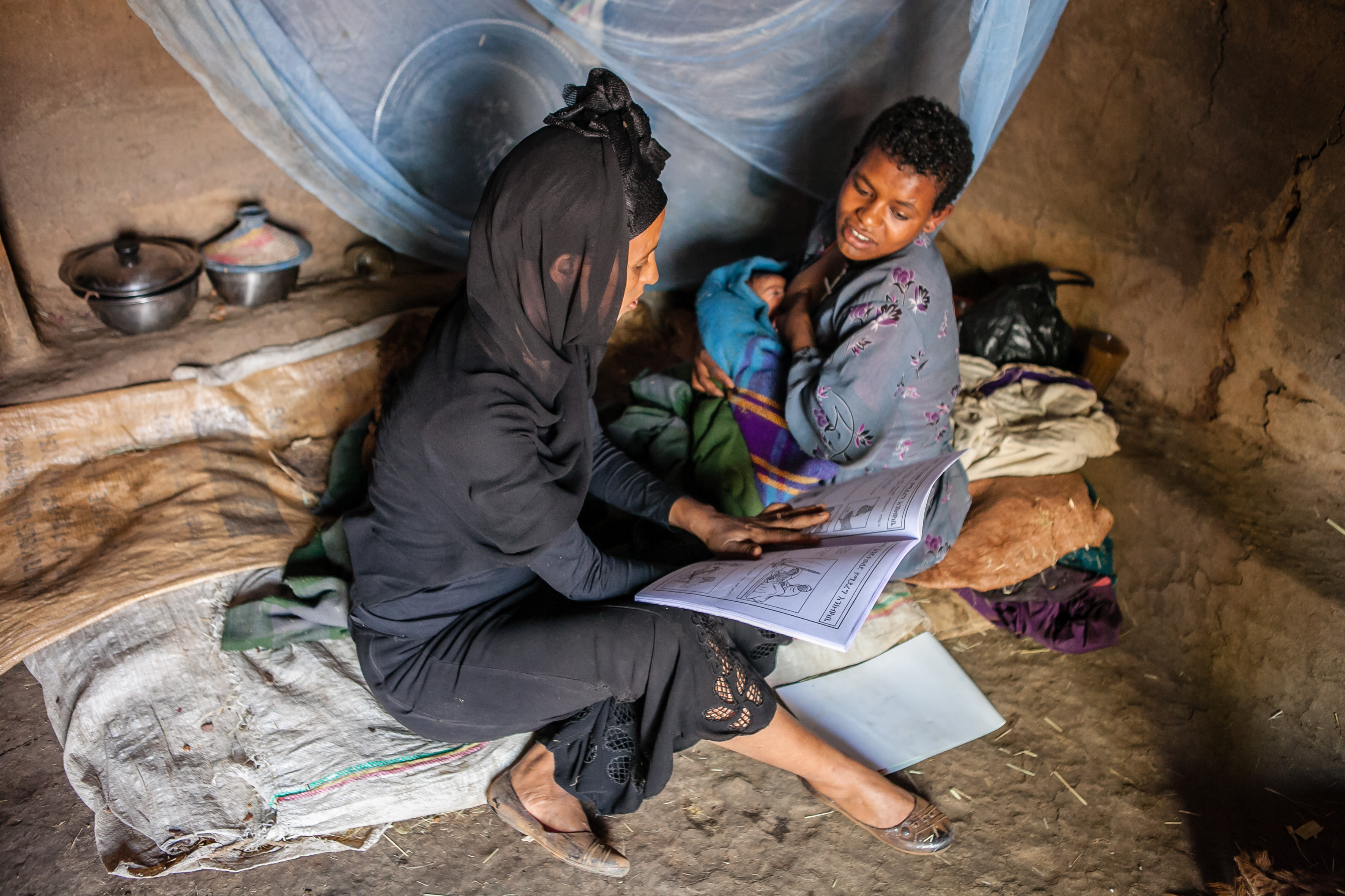A community health care worker visits a mother in her home.